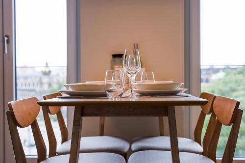 a wooden table with glasses and plates on it at UNiQE Apartments Oldtown - citycenter in Dresden