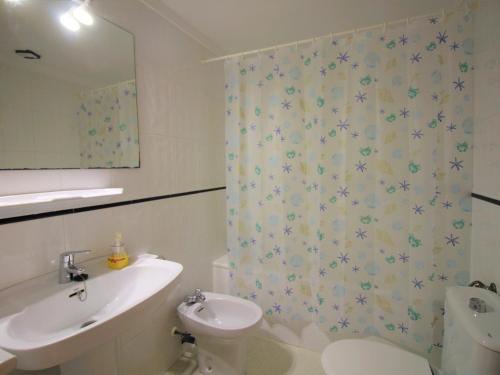 La salle de bains est pourvue d'un lavabo, de toilettes et d'un rideau de douche. dans l'établissement Apartamento Llançà, 2 dormitorios, 6 personas - ES-228-155, à Llançà