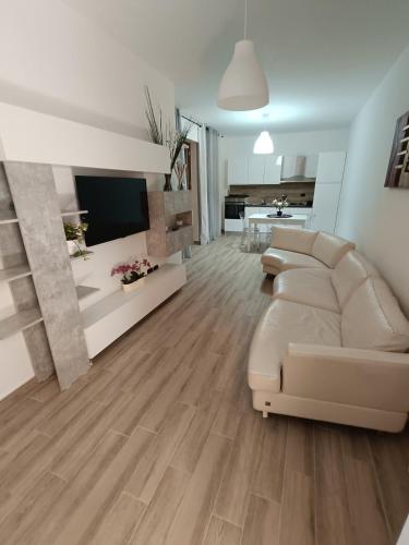 Casa Calatia في Maddaloni: غرفة معيشة بها أريكة وتلفزيون