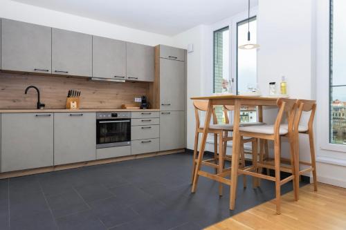 a kitchen with white cabinets and a table and chairs at UNiQE Apartments Oldtown - citycenter in Dresden