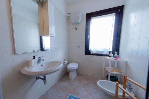 a white bathroom with a sink and a toilet at Casa Martina in Pula