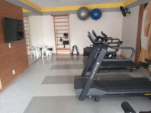 a gym with a treadmill and a flat screen tv at O melhor apt 1 quarto da Serra -ES in Serra