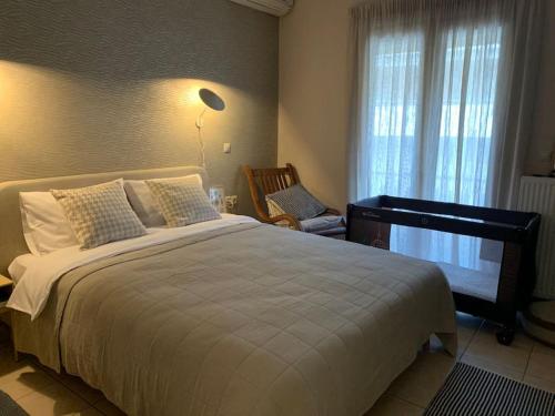 a bedroom with a large white bed and a chair at Amarillo Apt. Nafplio Downtown in Nafplio