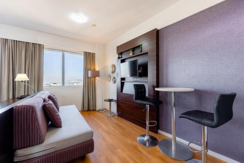 a hotel room with a bed and two chairs at STD - Anora Spaces - Stadium Alphaville in Barueri
