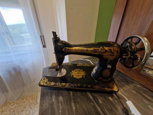een oude naaimachine bovenop een tafel bij Maremma Nel Tufo Centro in Pitigliano