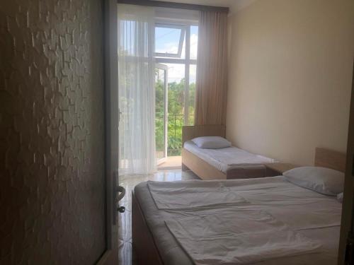 a bedroom with two beds and a window at Отел Нана in Kobuleti