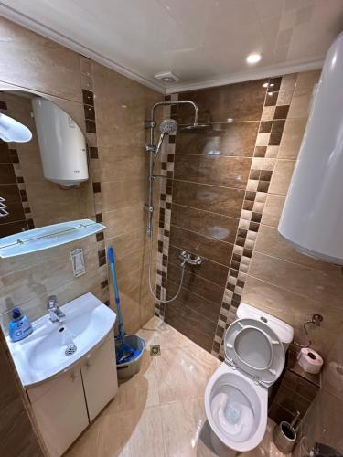 une salle de bains avec lavabo, toilettes et douche dans l'établissement Апартамент Lotus, à Varna