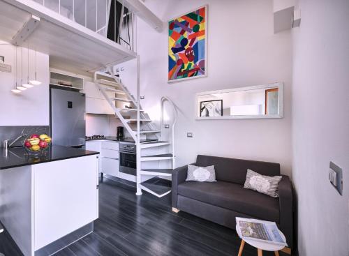 - un salon avec un canapé et un escalier en colimaçon dans l'établissement STUDIO THE BEACH - Regarda Travel, à Bardolino