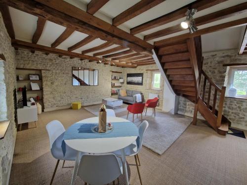 un salon avec une table et des chaises dans l'établissement Domaine de Houtteville - Gîtes - Omaha Beach Normandy, à Surrain