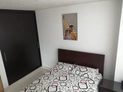 1 dormitorio con 1 cama y una foto en la pared en Casa 4, en Medellín