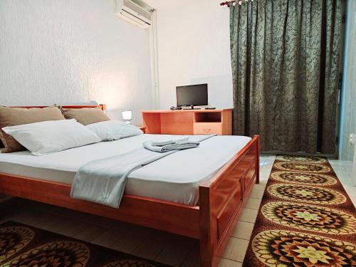 ein Schlafzimmer mit einem großen Bett und einem TV in der Unterkunft Bravo Plus in Budva