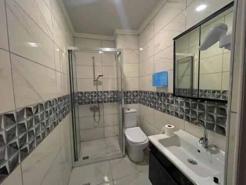 ein Bad mit einer Dusche, einem WC und einem Waschbecken in der Unterkunft Peralas Otel in Istanbul