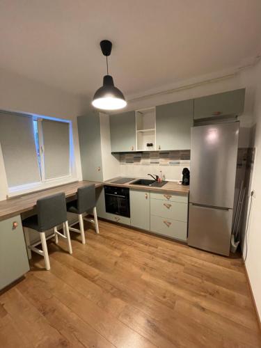 a kitchen with white cabinets and a stainless steel refrigerator at Arena Studio in Piteşti
