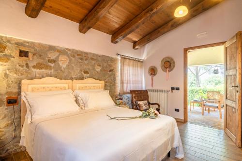 una camera da letto con un grande letto bianco e un muro in pietra di Tenuta Di Maro a Sticciano