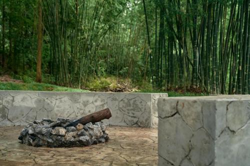 a pile of logs sitting next to a stone wall at Baan Rai Santisuk in Ban Sok Dua
