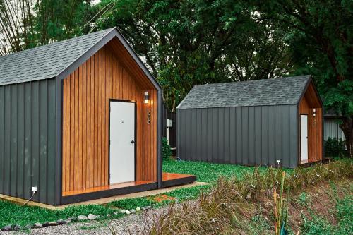 two storage sheds in a yard with a door at Baan Rai Santisuk in Ban Sok Dua