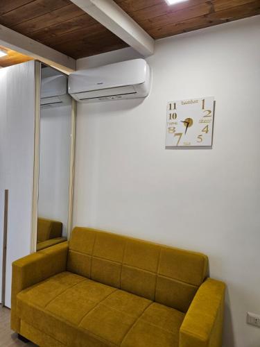 a couch in a room with a clock on the wall at Santalucia Apartment in Modugno