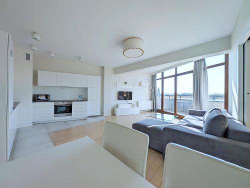 克拉科夫的住宿－Turnau City Aparthotel，一间带大蓝色沙发的客厅和一间厨房