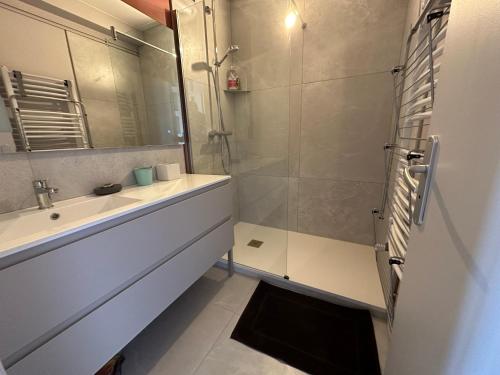 W łazience znajduje się umywalka oraz prysznic z lustrem. w obiekcie Devant les grands chalutiers w La Rochelle