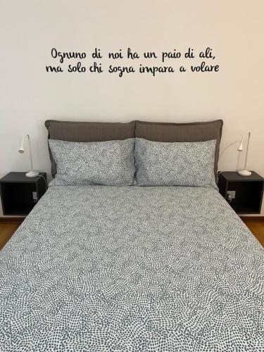 un dormitorio con una cama con una cita en la pared en Game,set and LOVE -Loft nel cuore di Aosta cir0389, en Aosta