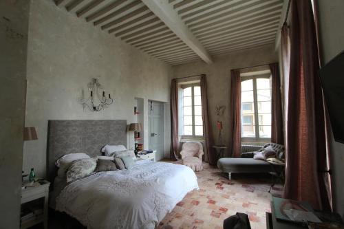 ein Schlafzimmer mit einem Bett, einem Sofa und Fenstern in der Unterkunft Luxury Retreat in Valréas in Valréas