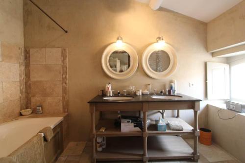 ein Badezimmer mit zwei Waschbecken und einer Badewanne in der Unterkunft Luxury Retreat in Valréas in Valréas