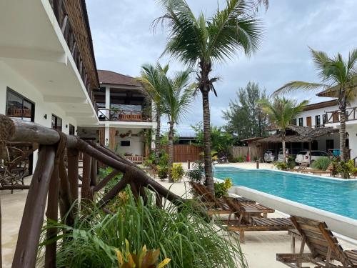 a view of a resort with a pool and palm trees at Sand Beach Boutique Hotel in Bwejuu
