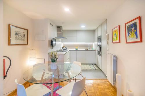 a kitchen and dining room with a glass table and chairs at Descansa en un sitio agradable in Pamplona