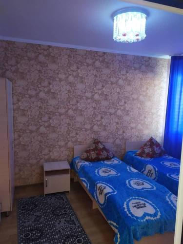 a bedroom with two beds and a chandelier at Нур пансионат in Bosteri
