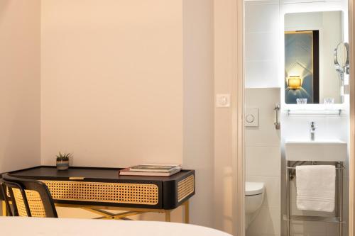 a small bathroom with a desk and a sink at Hôtel Le Nautilus in Saint Malo