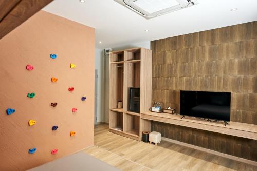 a living room with a wall with a flat screen tv at Baan Rai Santisuk in Ban Sok Dua