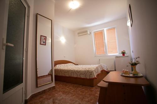 a small bedroom with a bed and a mirror at CASA PHOENIX in Eforie Nord
