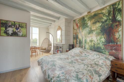 a bedroom with a bed and a large painting on the wall at Jacuzzi et Vue sur Loire - Maison d'hôtes L'Odyssée in La Chapelle-sur-Loire