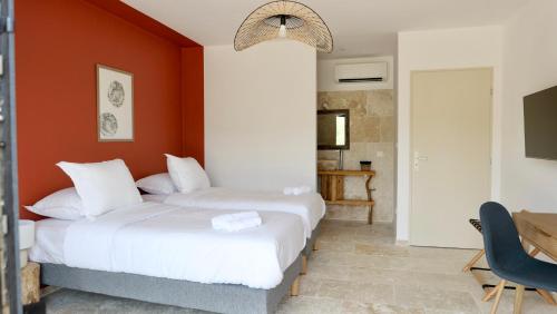 two beds in a room with an orange wall at A Machja in Olmiccia