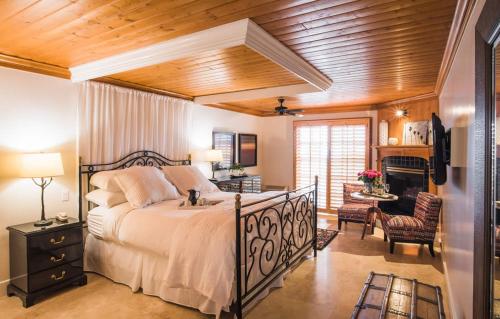 a bedroom with a large bed and a fireplace at Inn On SummerHill in Summerland