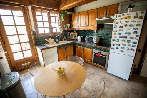 une cuisine avec une table en bois et un réfrigérateur blanc dans l'établissement Chambres Bords de Seine Vernon-Giverny, à Vernon