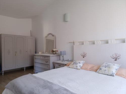 a bedroom with a bed and a dresser and a mirror at Residenze di Via Magnolie in Porto Ottiolu