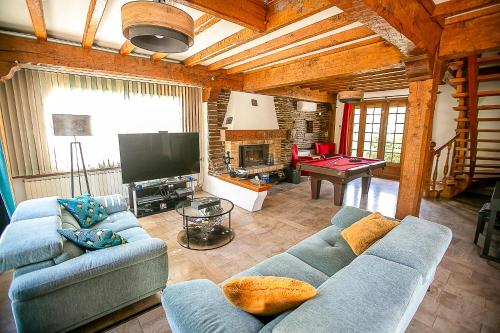 un salon avec un canapé bleu et une télévision dans l'établissement Chambres Bords de Seine Vernon-Giverny, à Vernon