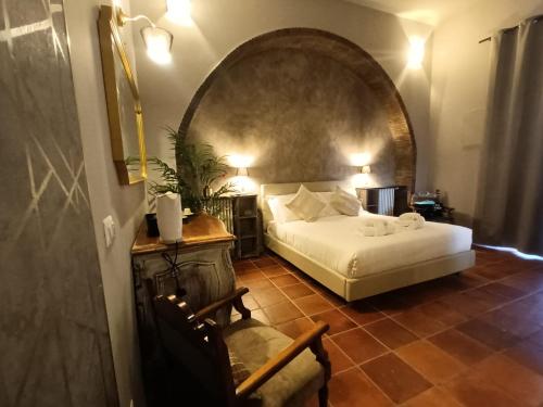 a bedroom with a bed and a chair in a room at Lucilla’s Suite San Pietro station in Rome