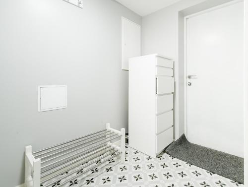 a white room with a refrigerator and a tiled floor at Nordnes Studio Apartment in Bergen