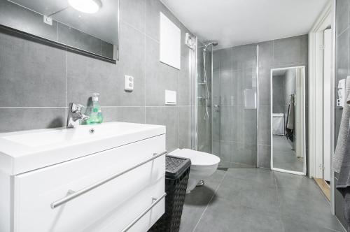 a bathroom with a sink and a toilet and a shower at Nordnes Studio Apartment in Bergen