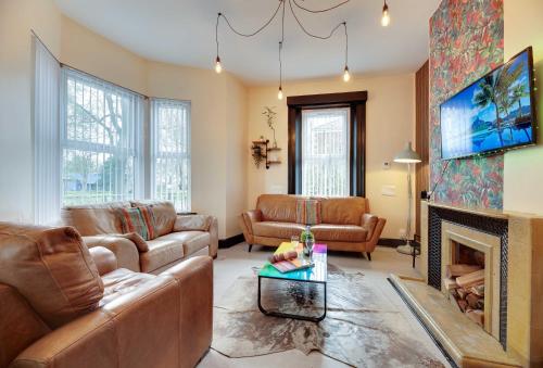 a living room with a couch and a fireplace at Newcastle CITY APT5,FREE STREET PARKING,4 BEDROOM HOUSE WITH 2 FULL BATHROOM AND KITCHEN,ALL ROOMS WITH TVs,7 BEDS,NETFLIX in Newcastle upon Tyne