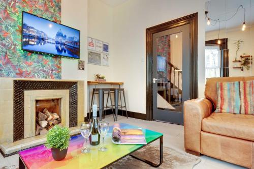 a living room with a couch and a fireplace at Newcastle CITY APT5,FREE STREET PARKING,4 BEDROOM HOUSE WITH 2 FULL BATHROOM AND KITCHEN,ALL ROOMS WITH TVs,7 BEDS,NETFLIX in Newcastle upon Tyne