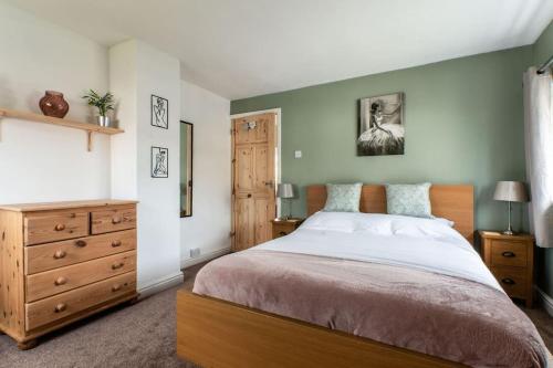 a bedroom with a large bed and a wooden dresser at Ivy House in Northampton
