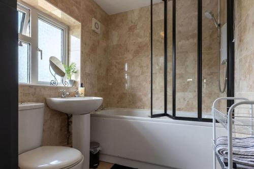 a bathroom with a tub and a sink and a toilet at Ivy House in Northampton