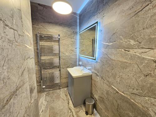 a bathroom with a sink and a mirror at ABBEY HOTEL in Stafford