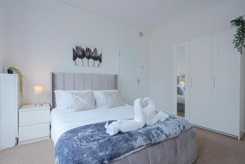 a bedroom with a bed with a stuffed animal on it at Modern Freshly Refurbed Home Luton in Luton