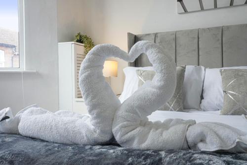 a bed with two swans made out of towels at Modern Freshly Refurbed Home Luton in Luton
