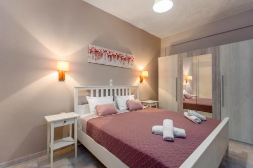 a bedroom with a bed with two towels on it at Amaryllis Boutique Apartments in Moraitika
