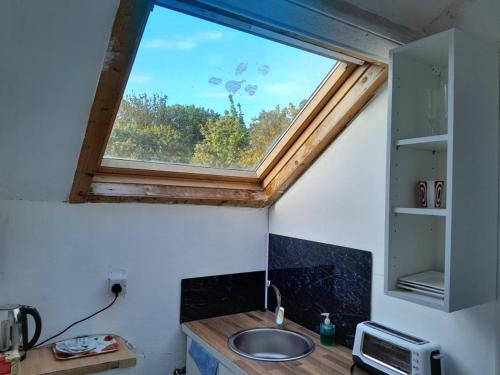 a bathroom with a sink and a window at Loft studio Singleton in Swansea